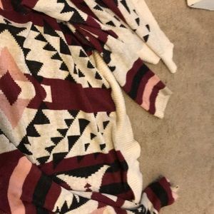 A  red and black and cream colored sweater